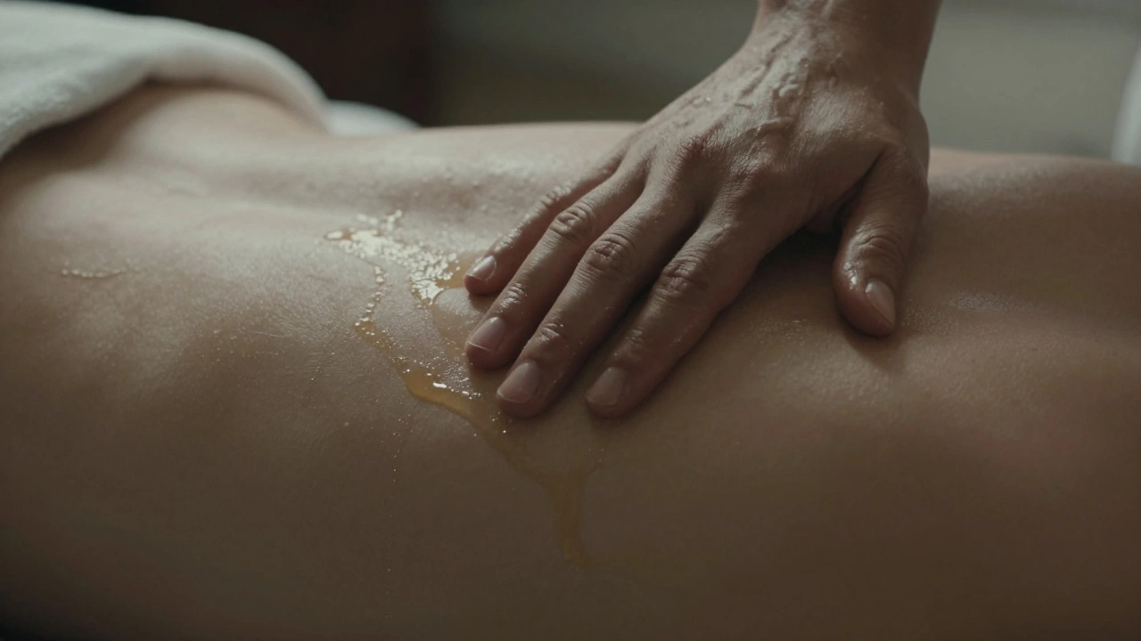 A hand gently applying oil to a bare back covered by a thin sheet during a sensual massage.