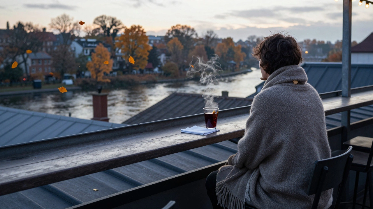 A solitary figure wrapped in a shawl at dawn, gazing over a river lined with golden autumn leaves from a rooftop terrace.
